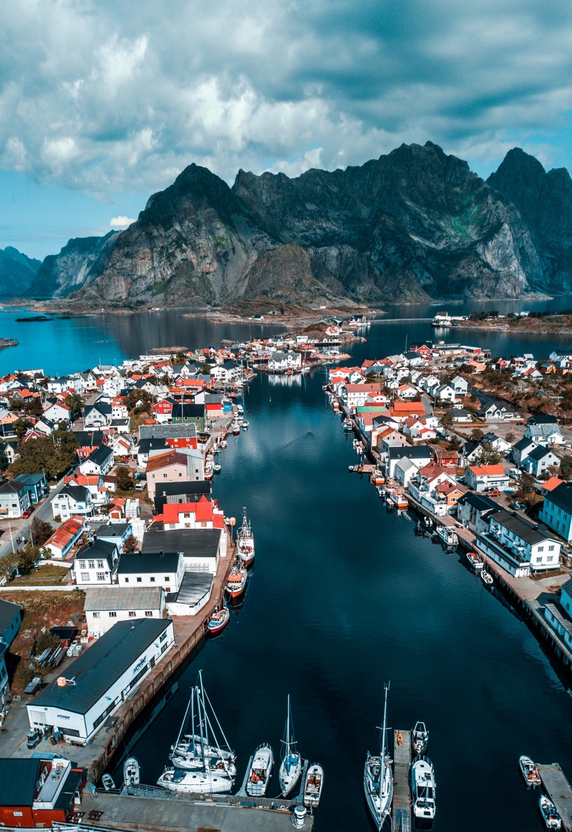 Liten by omringet av fjell og fjord.